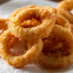 Knusprig gebackene Zwiebelringe auf einem Teller serviert